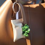 Close-up of the Gold Handmade Poop Bag Holder attached to a purse.